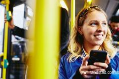 Mujer sonriendo con su teléfono en mano. Está en LinkedIn