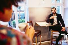 Hombre y mujer platicando con café en mano en cafetería