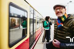 hombre sonriendo esperando el subway