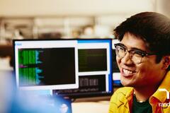hombre sonriendo desde su computadora