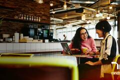 dos mujeres platicando en una cafetería.