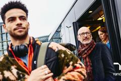 hombre de la generación Z con un hombre baby boomer bajando del autobús.