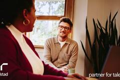 una mujer líder dando retroalimentación a un hombre de su equipo de trabajo.