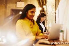 dos mujeres trabajando en la oficina desde su computadora.