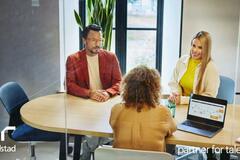 tres personas platicando en una oficina.