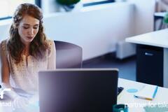 una colaboradora en su computadora mejorando su perfil de LinkedIn.