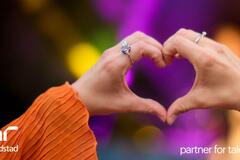 Primer plano de una persona haciendo un gesto con la mano en forma de corazón.