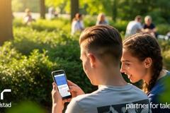 Un joven y una joven sentados en un banco en un parque.