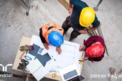 3 trabajadores en una planta haciendo planos.