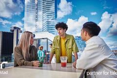 3 colaboradores platicando en la terraza de un edificio.
