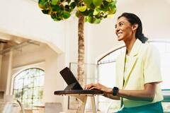 mujer sentada escribiendo en su computadora 