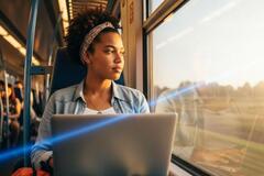 una mujer viajando en tren mientras trabaja.