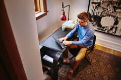 Hombre sentado en un escritorio con su computadora