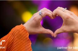 Primer plano de una persona haciendo un gesto con la mano en forma de corazón.
