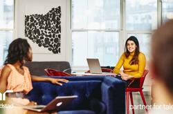 dos mujeres platicando en la oficina.