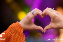 Primer plano de una persona haciendo un gesto con la mano en forma de corazón.