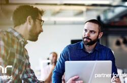 Dos hiombres platicando en su escritorio