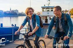  Dos jóvenes bajan de un ferry en bicicleta y disfrutan de un día soleado junto al agua. Generado por IA.