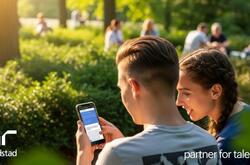 Un joven y una joven sentados en un banco en un parque.