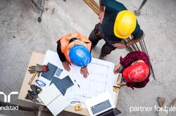 3 trabajadores en una planta haciendo planos.