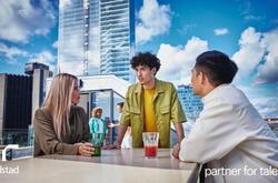 3 colaboradores platicando en la terraza de un edificio.