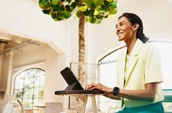 mujer sentada escribiendo en su computadora 