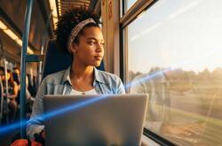 una mujer viajando en tren mientras trabaja.