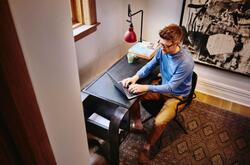 Hombre sentado en un escritorio con su computadora