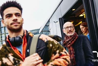 hombre de la generación Z con un hombre baby boomer bajando del autobús.