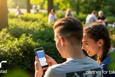 Un joven y una joven sentados en un banco en un parque.