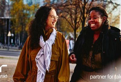 Dos mujeres sonriendo y platicando