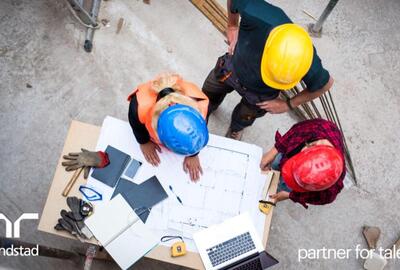 3 trabajadores en una planta haciendo planos.