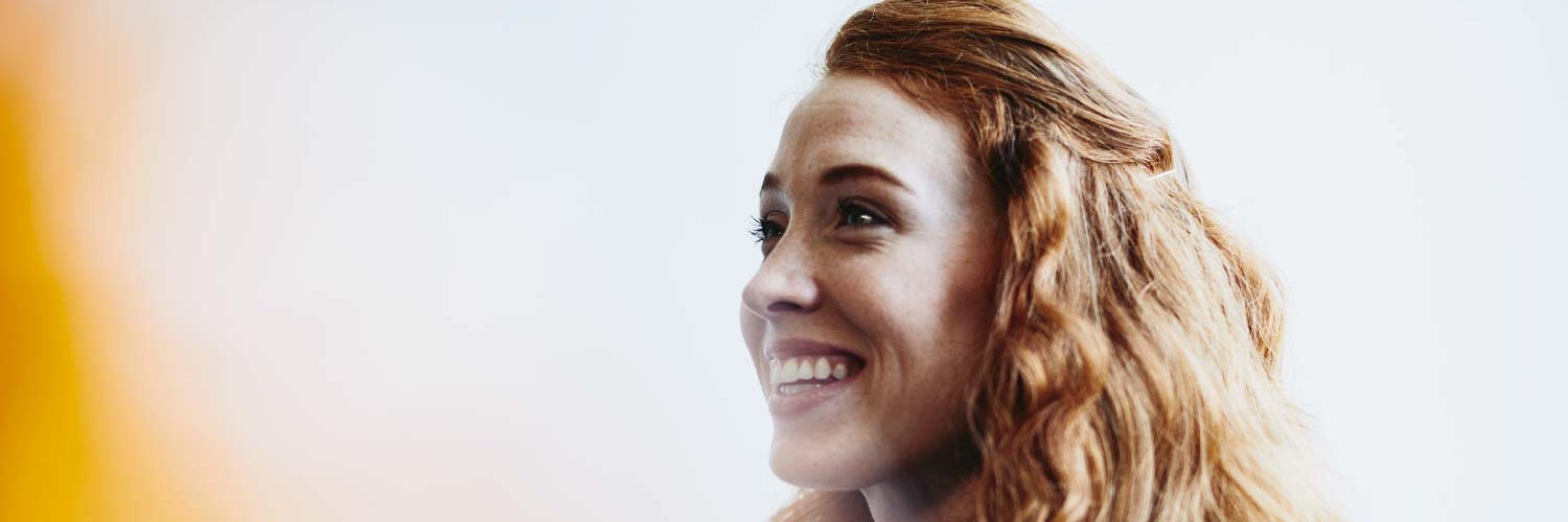 mujer rubia sonriendo por la contribución de Randstad al mundo del empleo